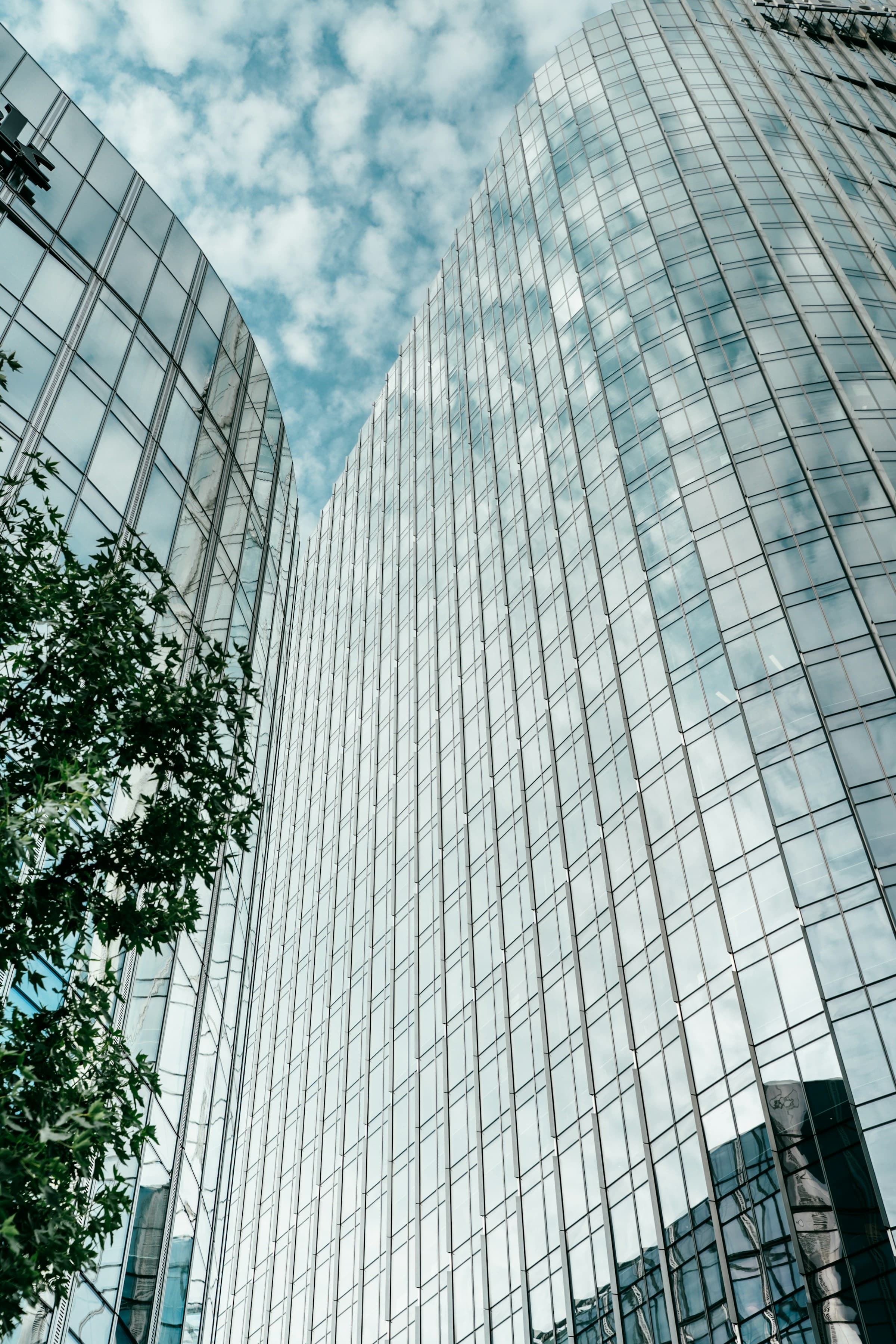 Modern glass office tower against a blue sky